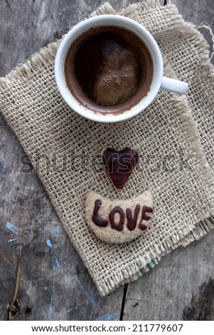 Coffee and love cookies on old wooden table