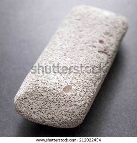 Raw pumice stone on table, light weight and with rough surface.