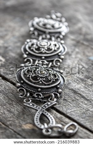 very old bracelet on a wooden background, Shallow depth of field