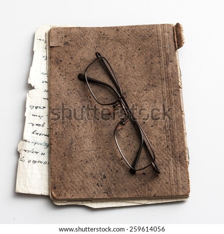 glasses and old notebook on table, from above