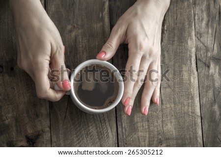 coffee cup in female hands, from above