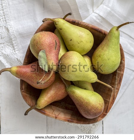 Fresh pears on white wooden table.