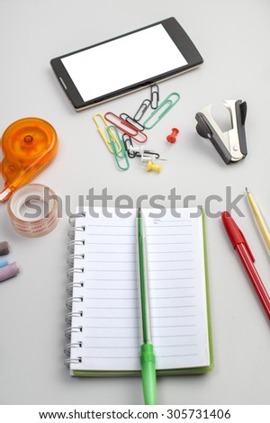 School materials such as crayons, notebooks, clips, stapler, prencils on table