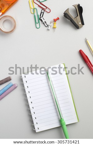 School materials such as crayons, notebooks, clips, stapler, prencils on table