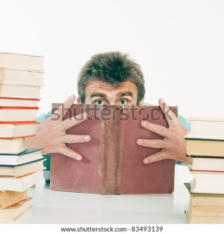 The person hides the face behind the old book. Back to school concept.
