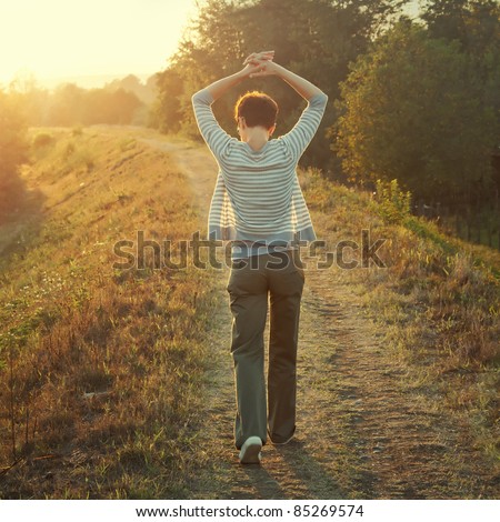 woman walking in nature late afternoon,tinted photo