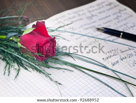 Lovely red rose and pen on a classic note book