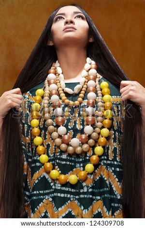 Woman in ethnic dress with long hair in the studio portrait