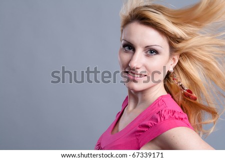 portrait of a beautiful girl in the studio on a gray background with flowing hair