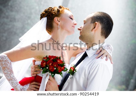 Bride and groom standing near a fountain