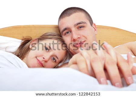 Happy man and woman laying in bed smiling and loving each other.