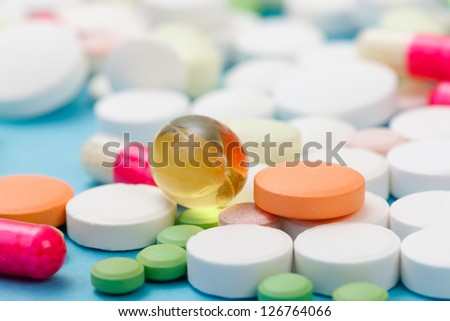 Various drugs, nutrient supplements and vitamins on blue background.