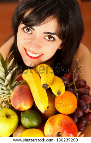 Plate of sliced fruits held by a smiling healthy girl.