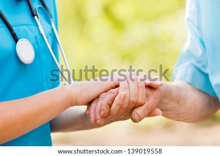 Doctor Or Nurse Holding Elderly Lady\'S Hands.