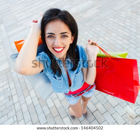 Attractive young lady with many shopping bags in the city center
