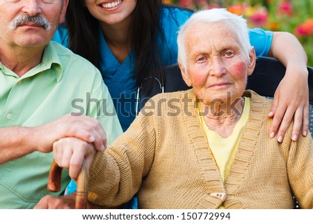 Elderly woman surrounded by family and doctor.