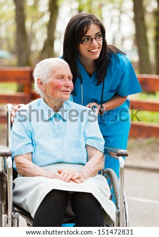 Elderly lady and nurse looking at the arriving visitors Elderly lady and nurse looking at the arriving visitors