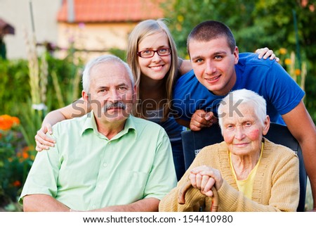 Happy multigenerational family visiting the elder member - the grandmother - in a nursing home.