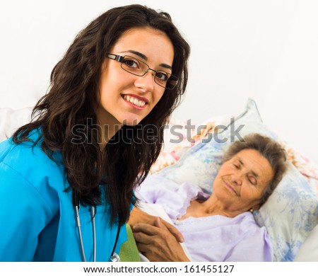 Smiling nurse caring for kind elder patient in nursing home.