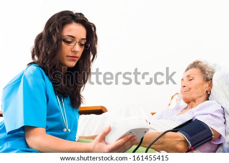 Nurse using digital blood pressure for senior patient Nurse using digital blood pressure for senior patient