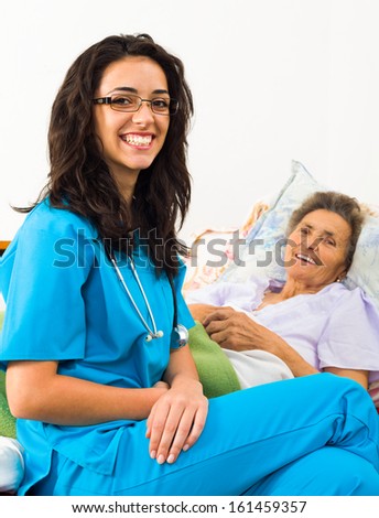 Happy joyful nurses caring for kind elderly patients helping their days in nursing home.