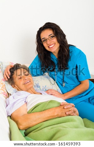Nurses caring for elderly patients suffering from disease in nursing home.