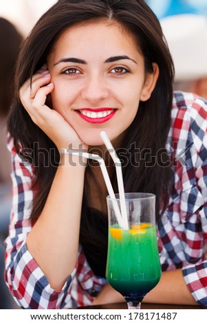 Gorgeous latina woman with beautiful brown eyes smiling with cocktail.