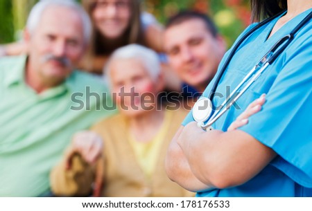 Doctor with stethoscope and happy family in the background medical care concept.