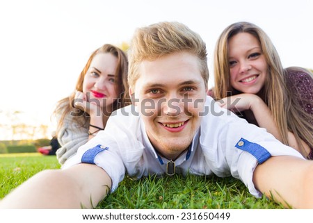 Young group selfie by a handsome young man and two girls - phone \'s point of view.