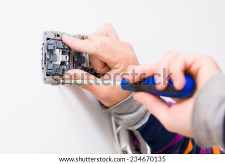 Electrical socket being mounted by electrician.