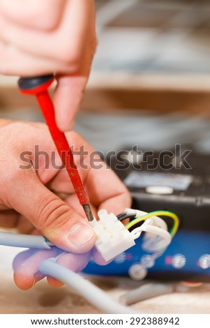 Electrician installing light in houses using tools and cords.