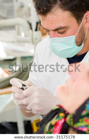 A young dentist preparing his turbine ( dental drill) for work - part of a series.