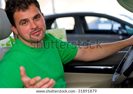 A young driver with a friendly face looking at the camera, like he is inviting \