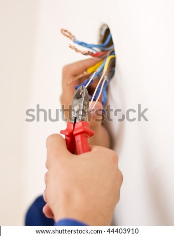 An electrician binding copper wires together and sealing them with insulation stripe.