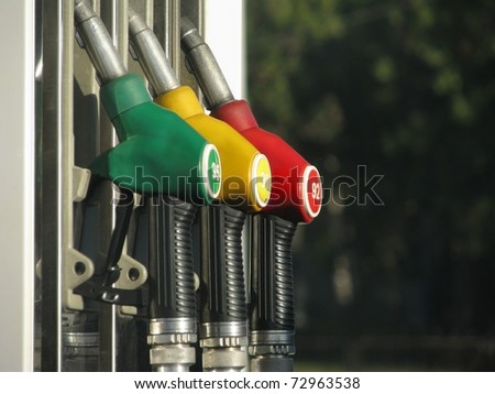 Green, yellow and red filling nozzles of the refueling station.