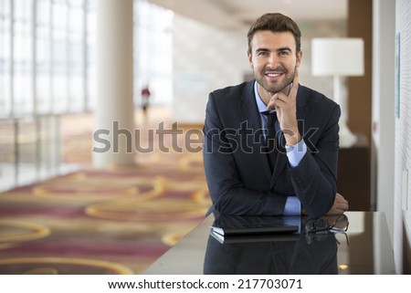Portrait of handsome businessman using the internet at the hotel lobby