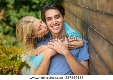 Lovers couple portrait showing affection for each other and a kiss on the cheek