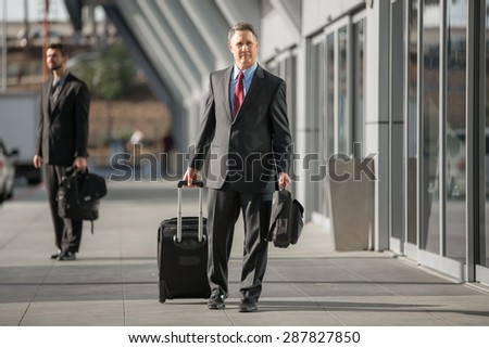 Traveling business man departs at the airport with luggage