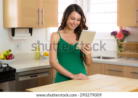 Happy female on her watching videos on her tablet computer while relaxing at home with perfect smile
