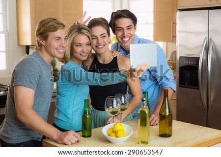 Best friends group together for a selfie in the kitchen at home party reunion college buddies