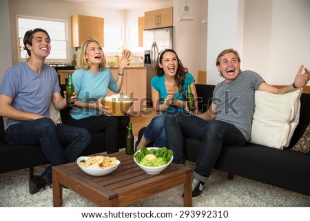 Attractive people at home watching television movie scary film enthusiastic