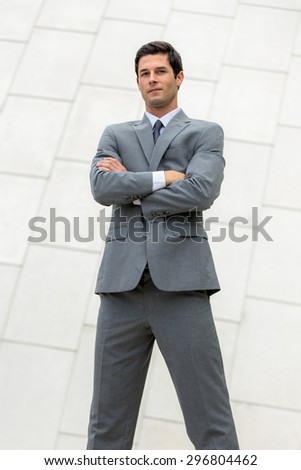 Vertical shot of very confident smug cocky business man executive posing powerful stance