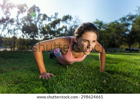 Powerful athlete woman strength training pushups outdoors in the morning