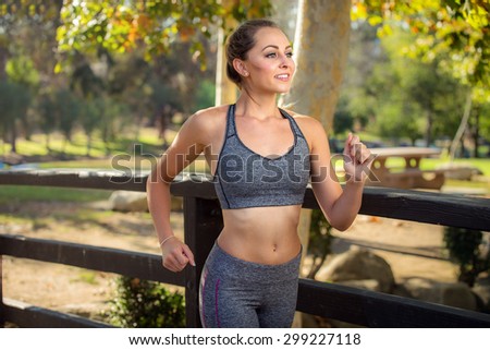 Beautiful female woman jogging in a park smiling joyful of the perfect day and health minded skinny fit in shape