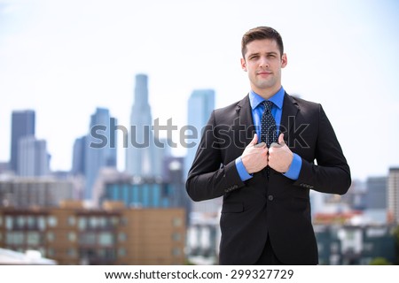 Confident businessman in a suit standing tall and proud attorney buildings in background