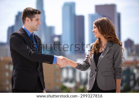 Male and Female business couple group leaders shaking hands downtown city