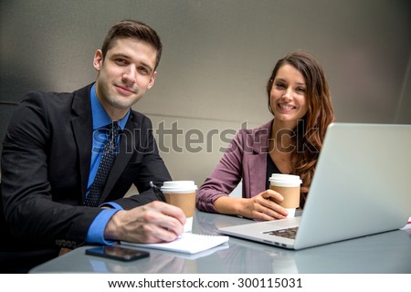 Two executives working late on a computer at a desk CEO boss with assistant