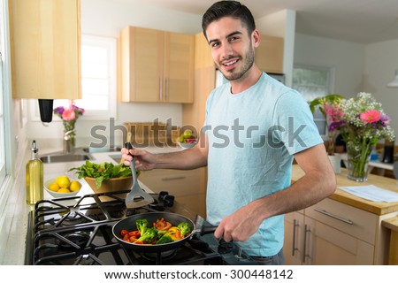 Single handsome man cooks at home alone a nutritious meal lunch dinner chef
