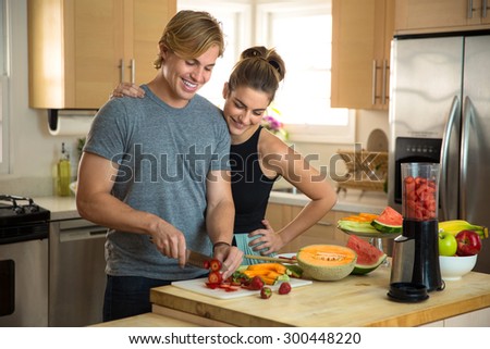 Happy young man and woman prepare a healthy recipe raw vegan lifestyle blonde handsome