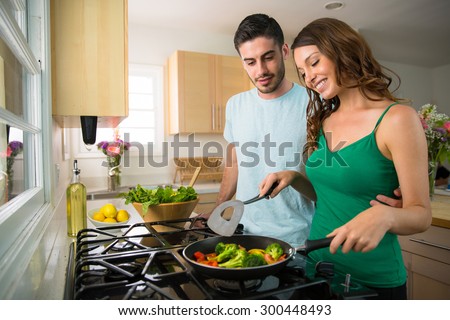 Attractive lovers couple cook together at home vegetables vegan diet health minded